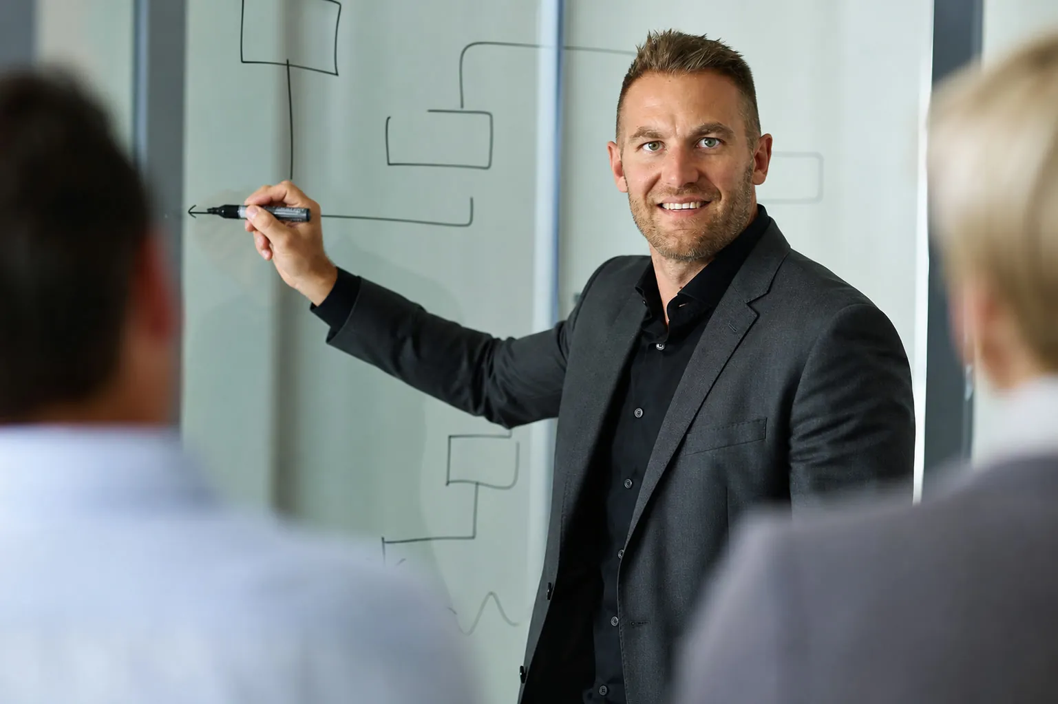 Brian Fürderer vermittelt eine regelbasierte Strategie am Glasboard