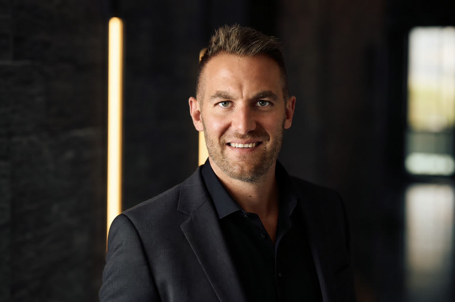 Porträt von Brian Fürderer vor dunklem Hintergrund