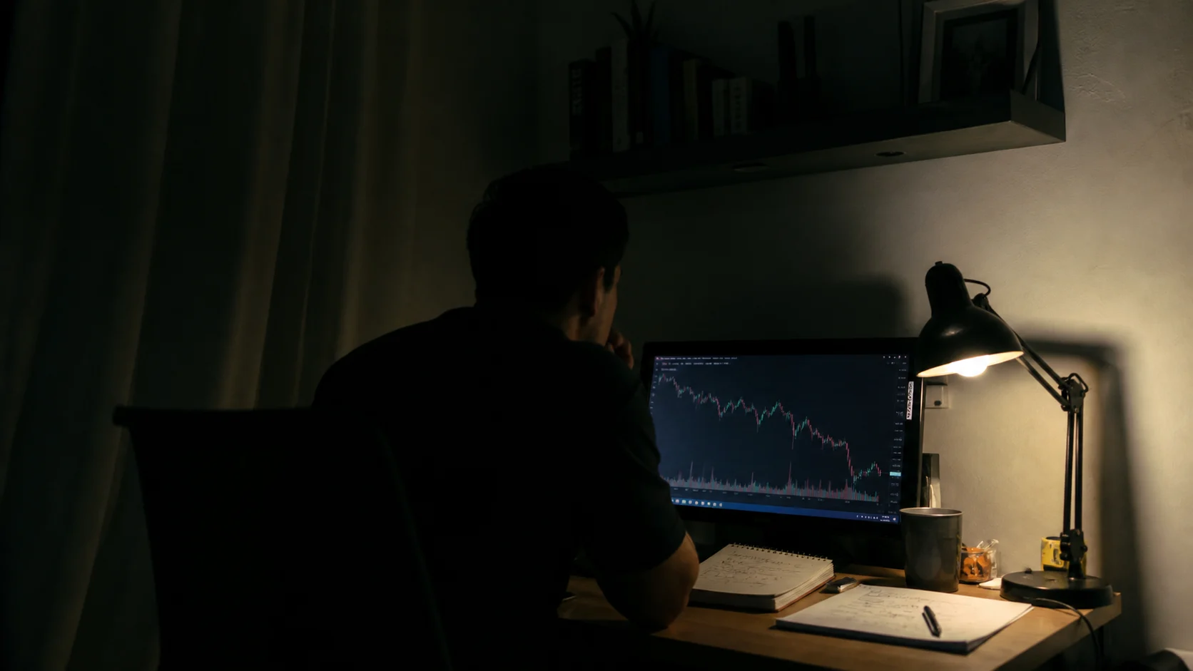 Person arbeitet im abgedunkelten Raum an einem Chart auf dem Bildschirm